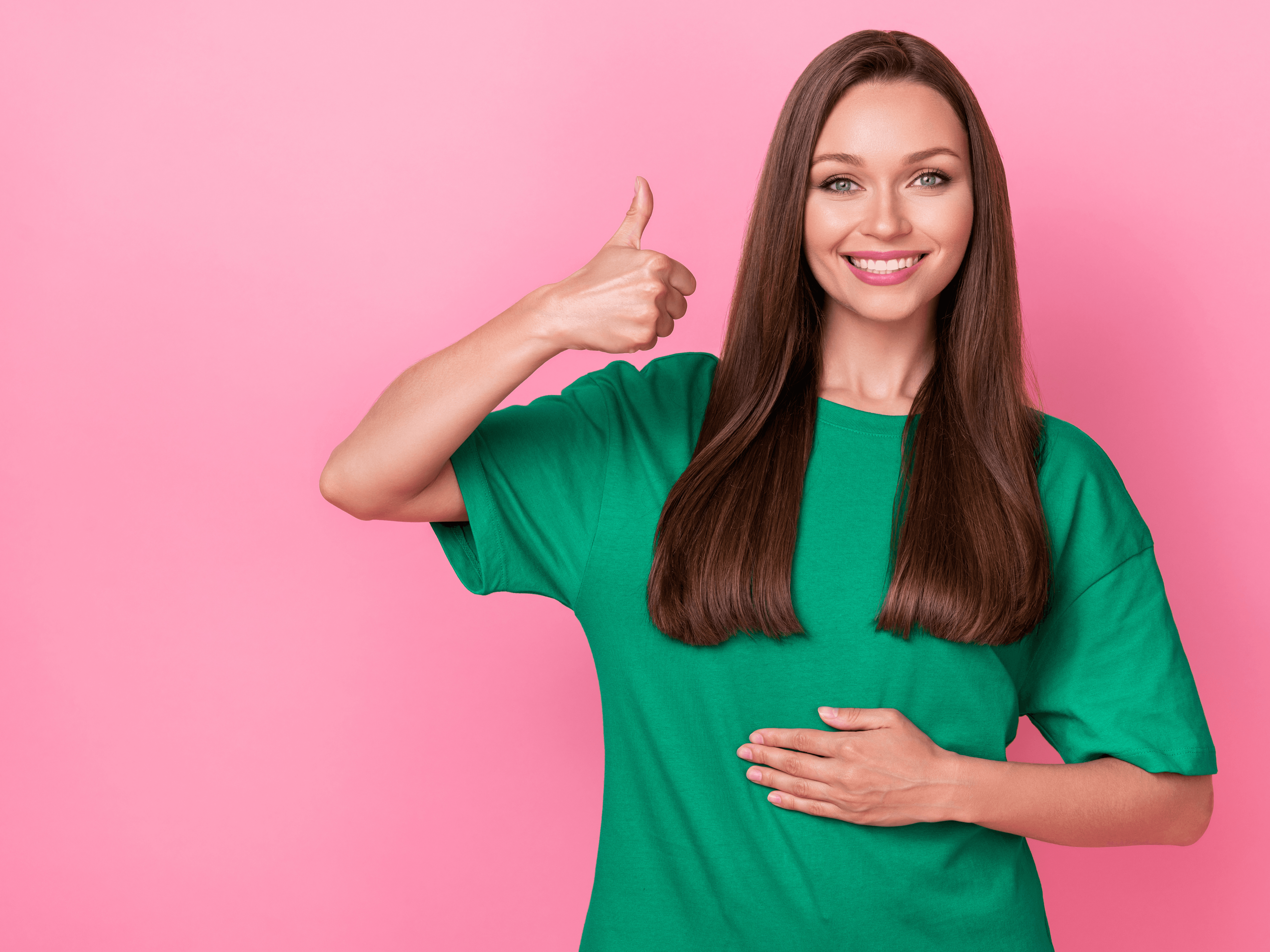 uśmiechnięta kobieta trzymająca dłoń na swoim brzuchu